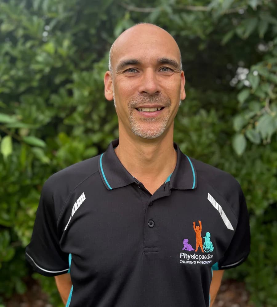 Michael Palomares, smiling, in his Physiopaedics polo